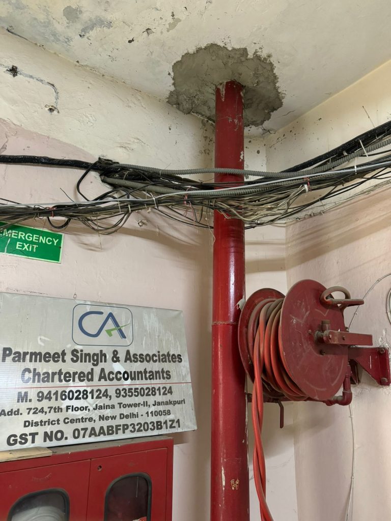 Fire riser penetrating slab, surrounded by cables